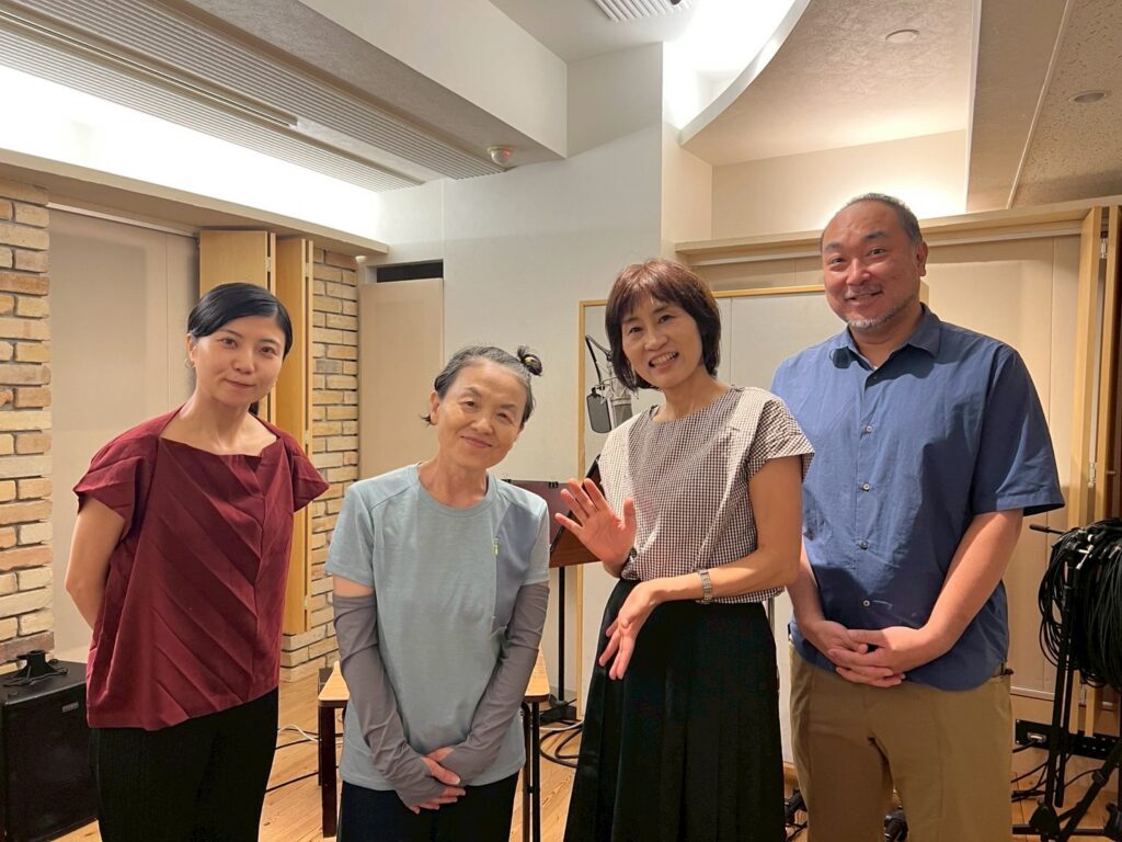 記念撮影、左から矢野ほなみ、浪曲師春野ココさん、曲師藤初雪さん、露曲台本家の西村卓也さん。明るい白めのスタジオで、奥にマイクだが立ってある。
